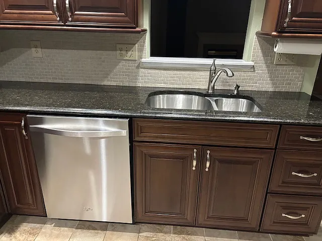 Tile backsplash. Double sinks. Facet with pull down spray hose for easy rinsing. Garbage disposal.