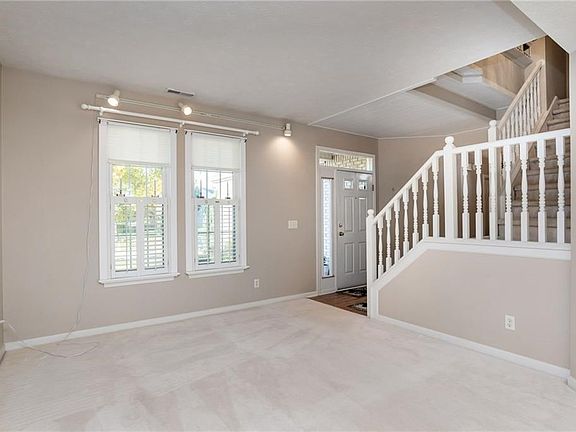 Plantation shutters in the Living Room and Family Rooms. Open Stairway to upper level.