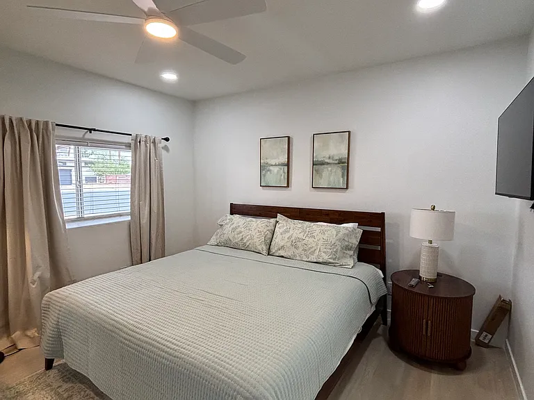 Comfortable king size bed with blackout curtains on the windows.