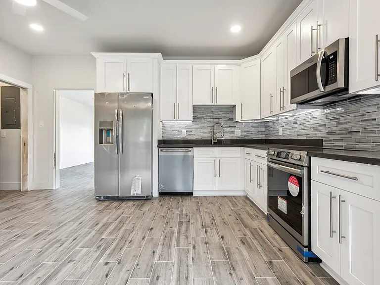 Kitchen area with door leading in to large front bedroom.