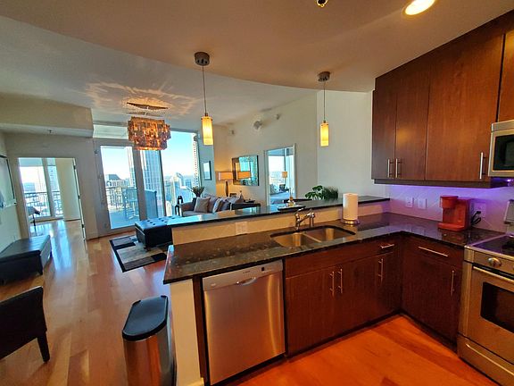 Kitchen with granite counter tops, stainless steel appliances (fridge, microwave, stove, oven, dishwasher, and sink with garbage disposal), and breakfast bar with stools. Condo come furnished and decorated as pictured.