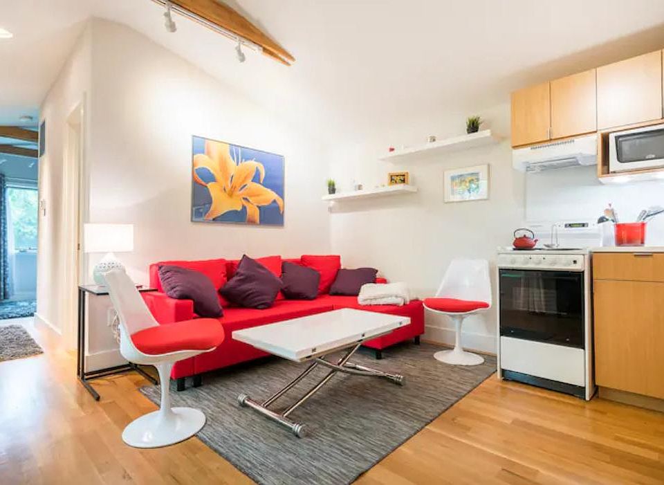Combined living room and kitchen area. If you choose to rent the apartment furnished, the table lifts and expands to form a larger workspace or dining table.