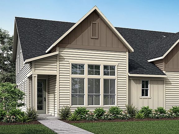 A two-story house with a gabled roof, wooden siding, and a covered porch sits on a grassy lawn surro