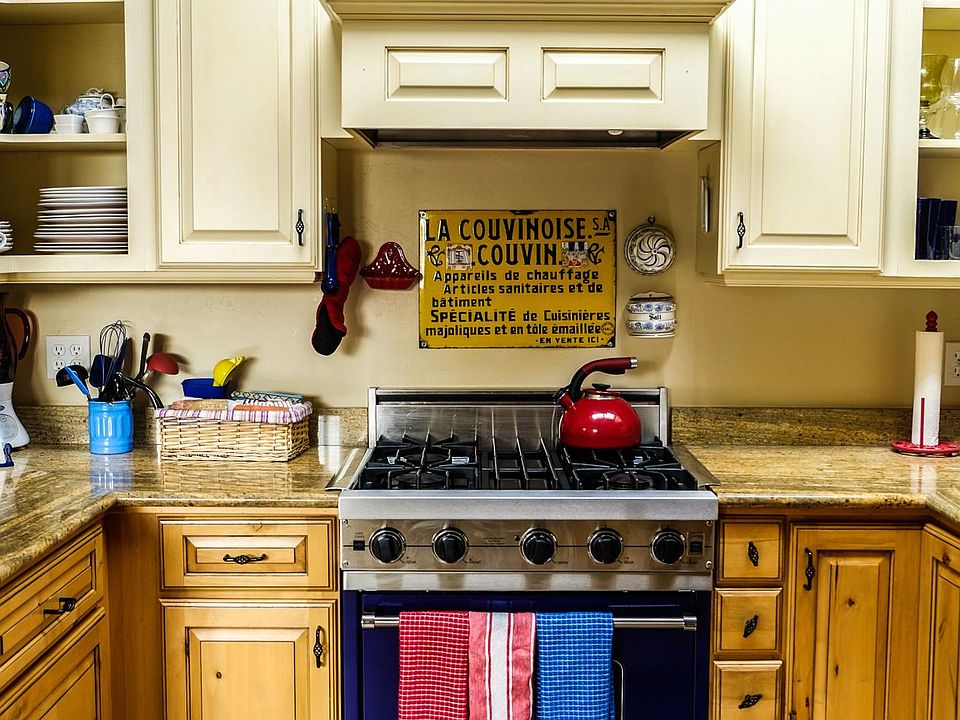 Cooking area of kitchen has a Cobalt Blue Viking stove, two sets of dishes, Bosch Dishwasher, Chef sink, double door refrigerator with ice maker.