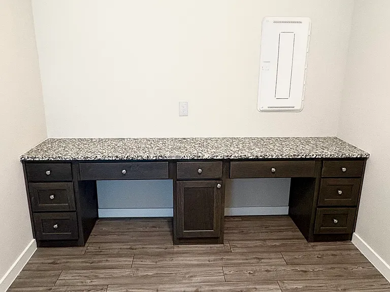 Built-in desk with granite counter top, 9 drawers and cabinet room for 2 desk chairs. Lighted ceiling fan. Laundry is on other side of the room.