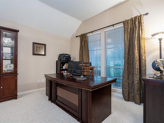 Located off the entry is the formal living area that is currently being used as a home office! Large picture windows offer views of the front yard and it's mature trees!