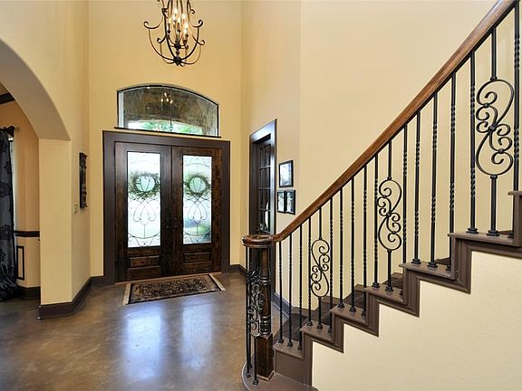 Enter the front doors to the beautiful foyer , study to the right.Stained concrete floors.Custom lighting throughout .Formal dining to the left.