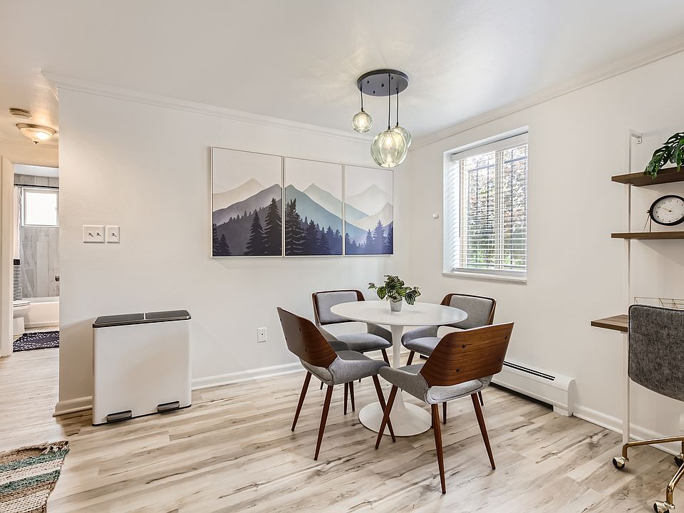 The open concept kitchen and dining area features a stylish dining table with seating for four. Down the hallway, you will find the bedroom and bathroom.