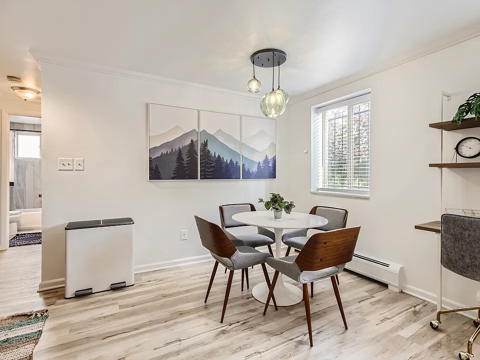 The open concept kitchen and dining area features a stylish dining table with seating for four. Down the hallway, you will find the bedroom and bathroom.