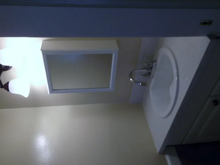 quartz counter in guest bath. Mirror is a medicine cabinet for extra storage. Light fixture is updated. Walls will be painted white.