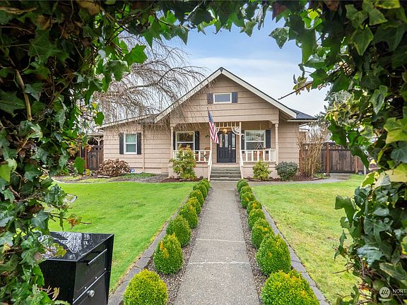 Enter through the front gate to a boxwood lined sidewalk leading to this charming abode. The front yard is fully fenced & features a lush landscape & curbed flower beds>