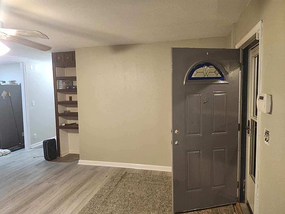 Front entrance to large Living room with wall storage.