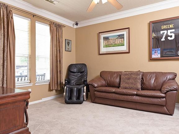 The living room has carpet, double crown moulding and a ceiling fan.