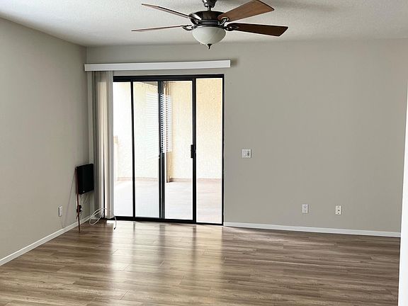 Spacious living room with vinyl plank flooring, ceiling fan/light combo