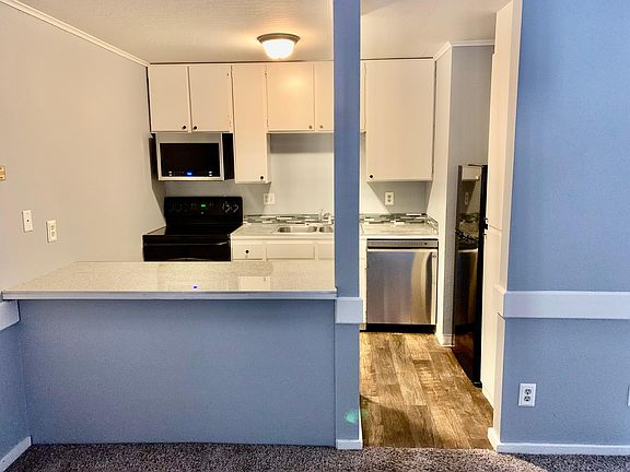 Updated kitchen with granite bar/island, new dishwasher. Ample storage including a full section of pull out drawers on other side of bar/island.