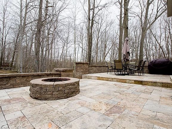 The Two Tier Travertine Deck with built-in fire pit and knee walls is a must see!  The Deck includes a 14' by 14' and 16' by 16'