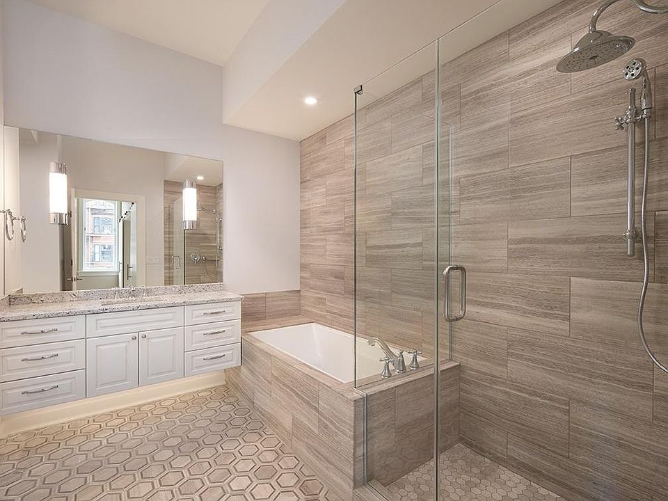 Beautifully tiled bathroom with soaking tub and spacious shower.