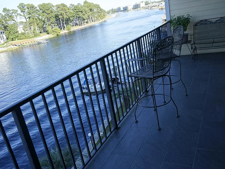 Slate tile floor on balcony with three sliding doors entering from the 2 bedrooms and living room.