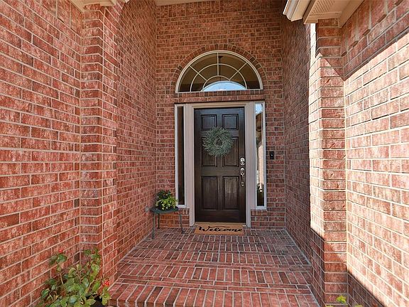 Covered front porch and pretty front door. Sidelight windows and arch window above the door let in lots of natural light.