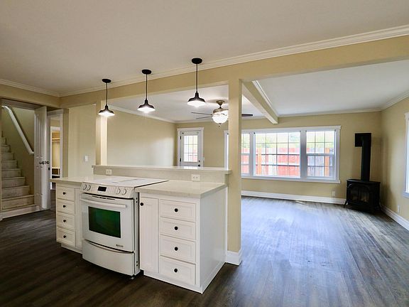 Kitchen opens to living room with Jenn-air downdraft stove