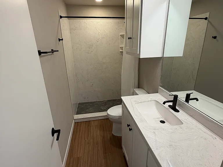 Marfa bath has a cultured marble shower and countertop with all new fixtures, custom cabinets, plumbing and electrical.