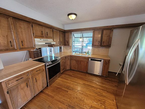 Kitchen with view into dining space, window looking onto backyard
