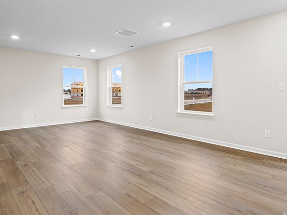 Living room with multiple large windows in a DRB Homes Glenshaw plan at The Village of College Park.