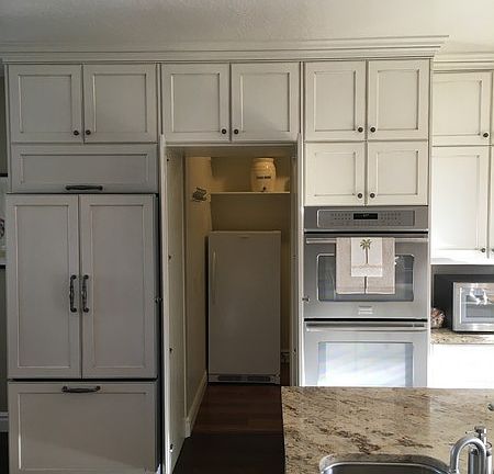 Large walk in pantry : Pantry has large shelves for storage and hanging rods for tablecloths