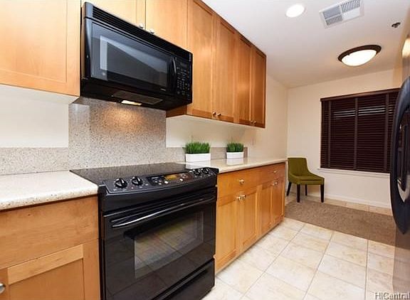 Granite kitchen counters with hard wood cabinets and newer appliances.