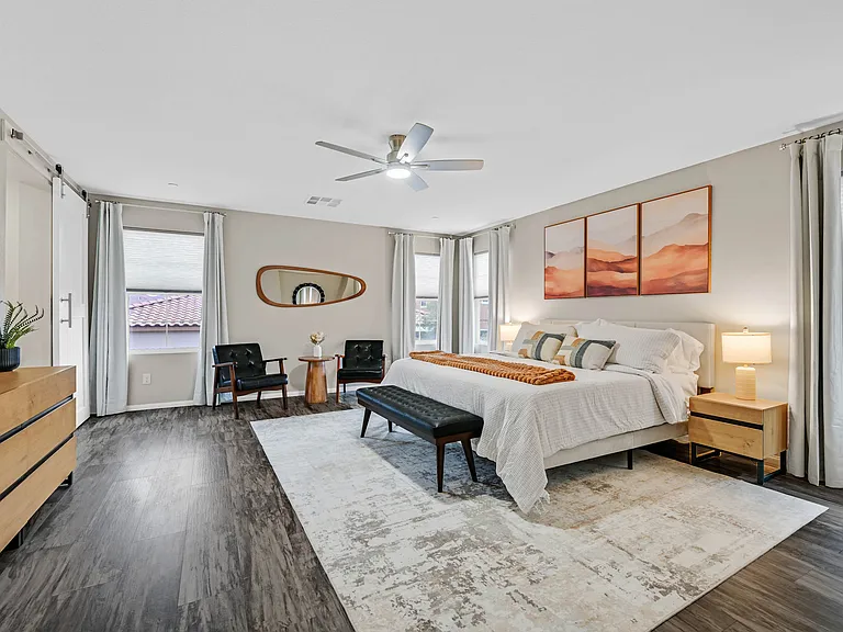 Master Bedroom with King size bed, walk-in closet, ceiling fan, black out curtains, sitting area, and desk