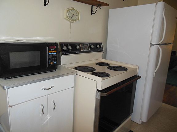 Kitchen: electric range, microwave, storage base with silverware drawer