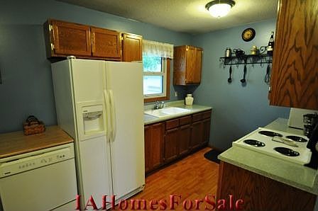 Kitchen - Eat in kitchen with modern oak cabinetry, wood laminate flooring and paint. Garbage dispos