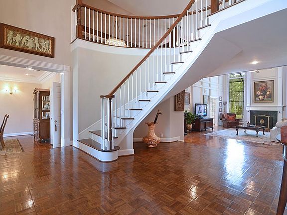 A step up front Porch leads to these regal, double leaded glass 8-foot doors that open to this impressive 2-story Foyer that has hand-laid refinished parquet floors, a gracefully curved stair, cased openings and heavy crown molding
