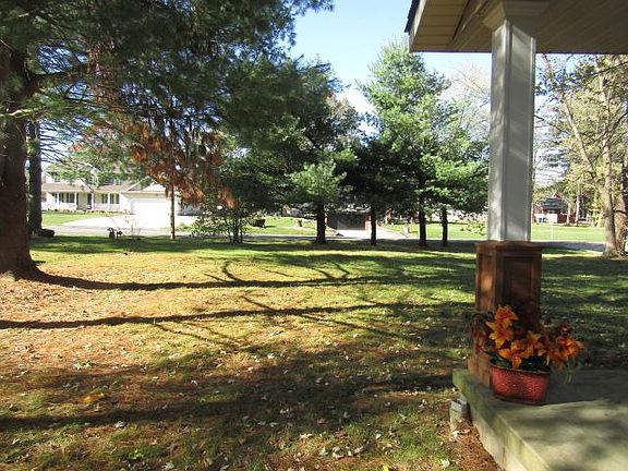 Front exterior view. Tree line in front of road and on both sides of house.