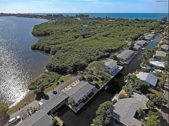The condo is located in the top right of the photo. This aerial view shows the 32-acre Joan Durante Park with a large pavilion, fountain, flower gardens, walking trails, boardwalks, and lagoon overlooks through the mangroves.