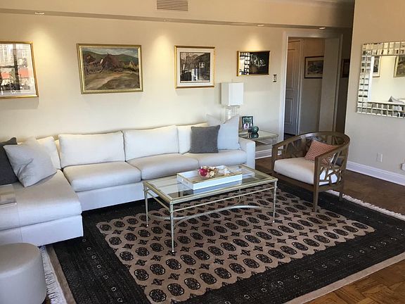 Spacious living room with parquet floors and recessed lighting looking north out to downtown Clayton