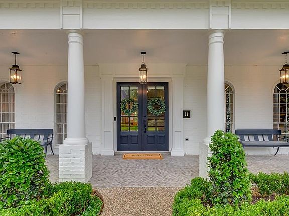 Huge covered front porch with charming lanterns and double front doors