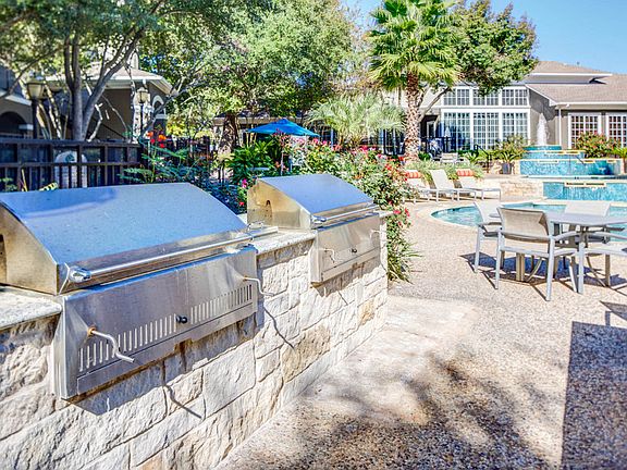 Charcoal BBQ Pits by pool and table seating
