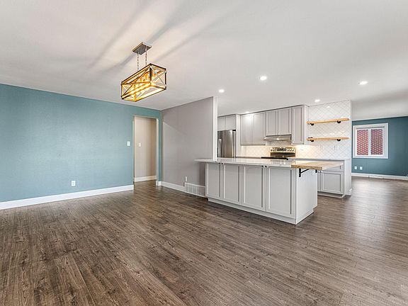 The formal dining room is open to the kitchen with plenty of space for extra barstools around the quartz counter.
