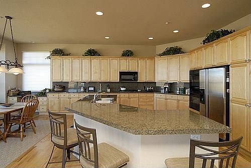 Gourmet kitchen with island and slab granite