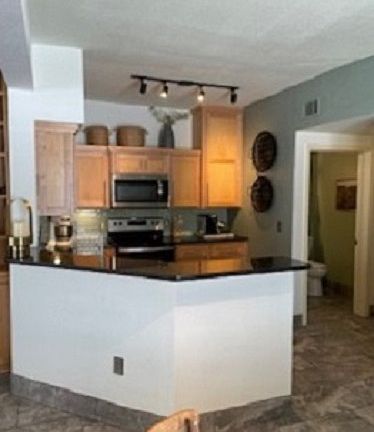 Kitchen has dishwasher, electric stove, disposal, custom cabinets and large refrigerator. First floor half bath is adjacent