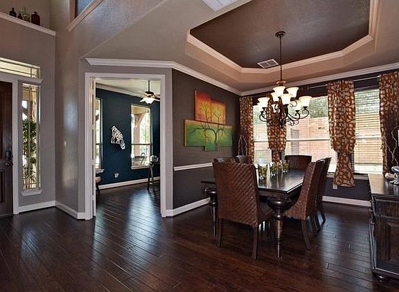 The formal dining room features a coiffured ceiling and hand scrapped hardwood floors which continue