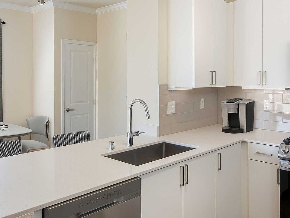 Renovated Package I kitchen and dining area featuring white cabinetry, white quartz countertops, stainless steel appliances, and hard surface flooring