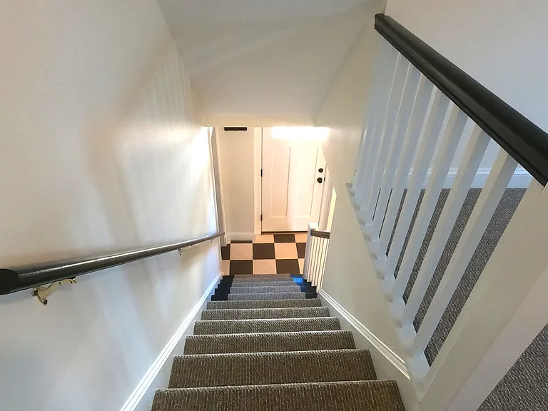 Stairs from media room/living room leading back down to the kitchen.