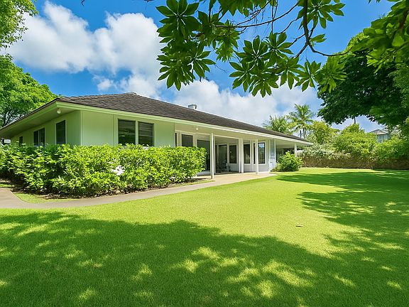 Expansive private backyard with lush greenery and a spacious lanai _ perfect for candlelit dinners or weekend BBQs. Island living at its finest!