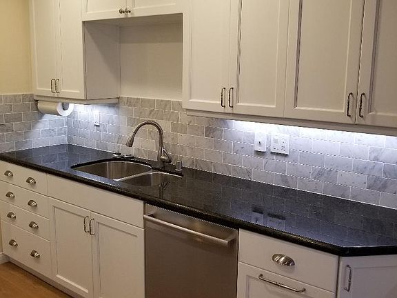 The kitchen features large granite countertops and abundant cabinets.