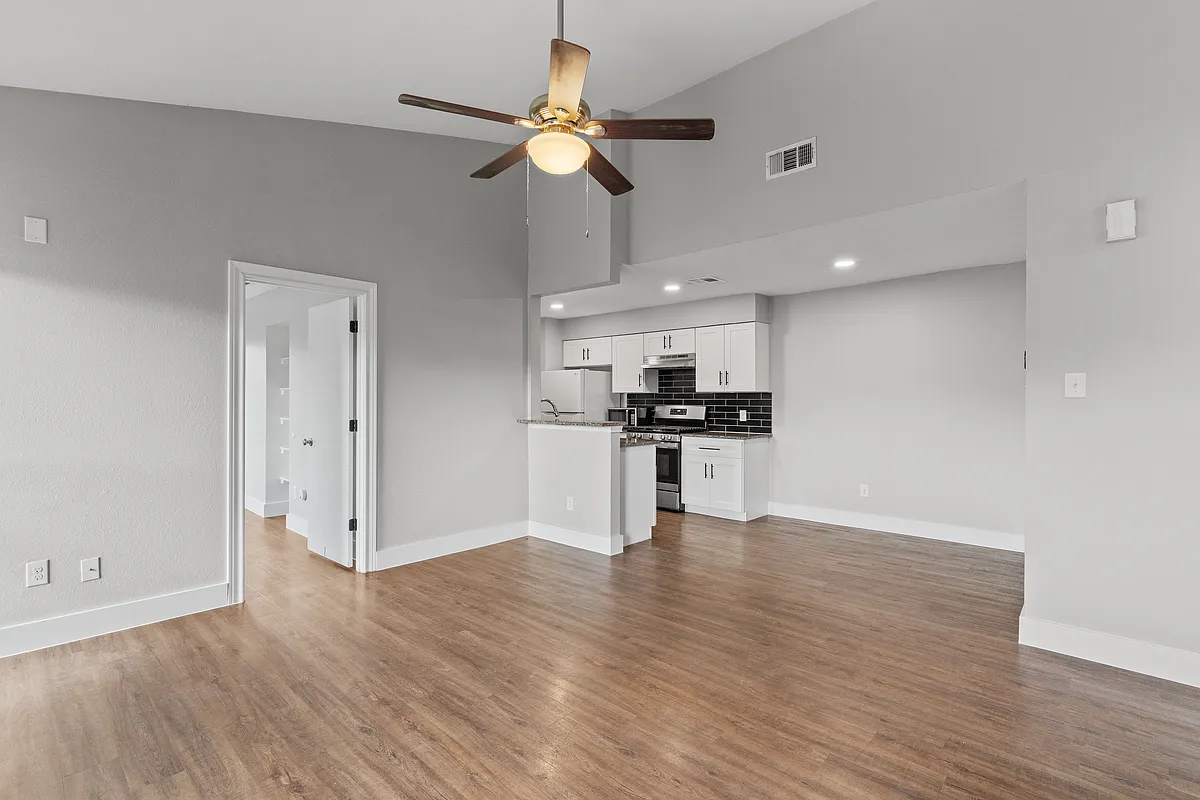 Living room looking into dining/kitchen. Door on the left is primary bedroom. - 602 Peterson St