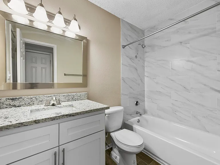 Beautiful restroom with granite counter tops, shower has tile.