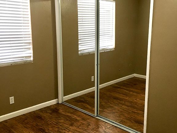 Bedroom 1: Hardwood floors, ceiling fan and mirrored closet doors
