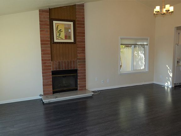 Centered on this cozy yet dramatic brick fireplace the living room enjoys high vaulted ceilings.  The dining room to the right h